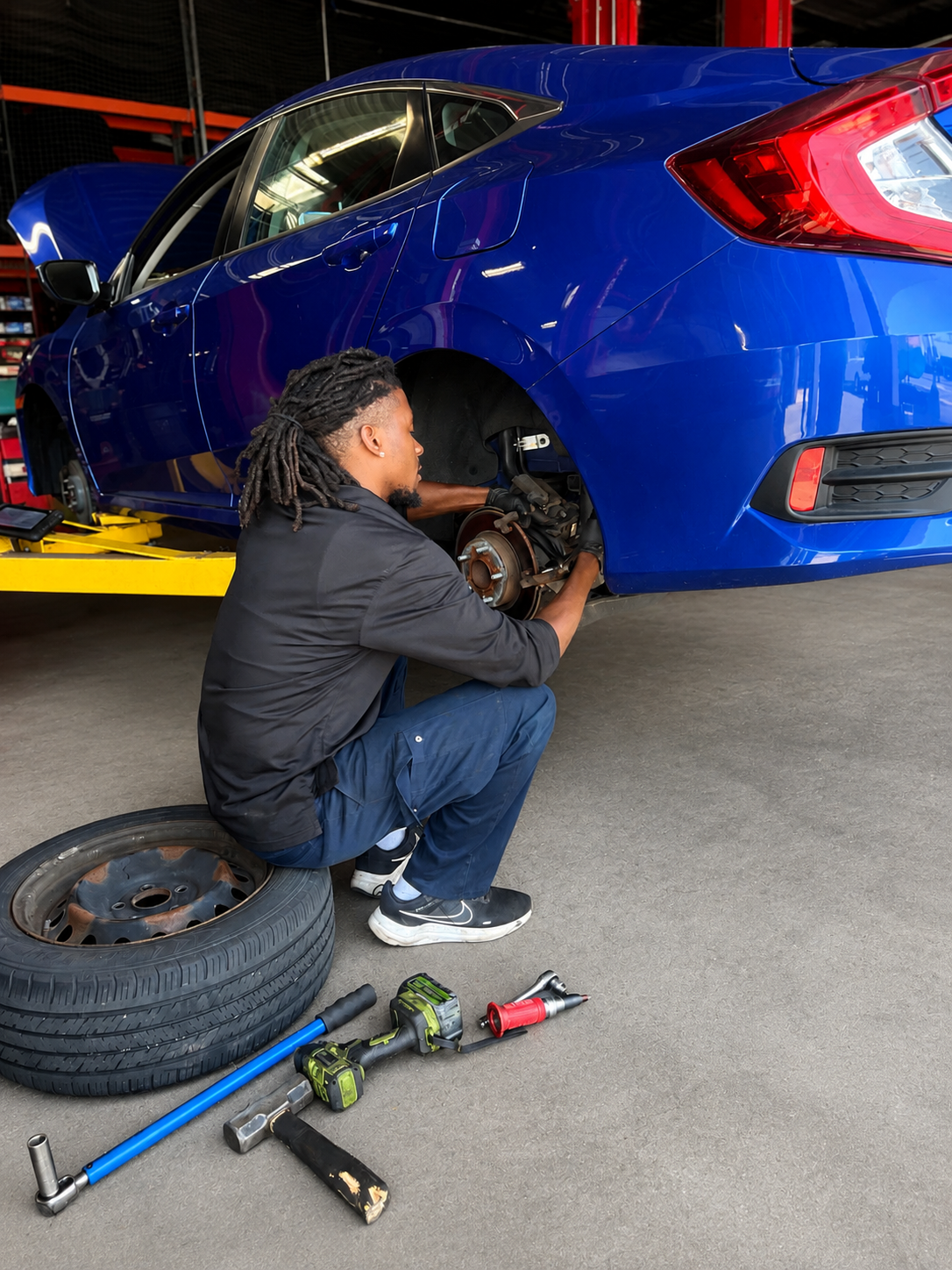 Valtek technician replacing brake pads on a blue sedan